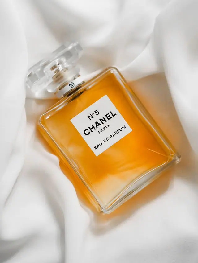 Chanel N°5 Eau de Parfum bottle resting on white silk